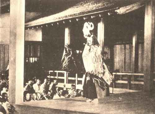 THE DRAGON LADY IN <I>AMA</I> HOLDING ALOFT THE SCROLL OF THE <I>HOKKEKYŌ</I><BR>
(BEHIND HER IS THE <I>HASHIGAKARI</I>)